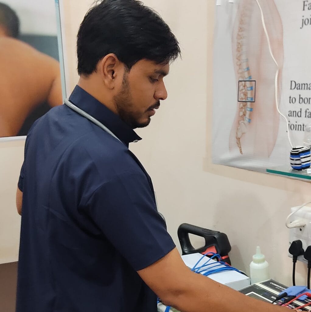 physiotherapist setting up electrotherapy equipment at PhysioCare247 clinic.