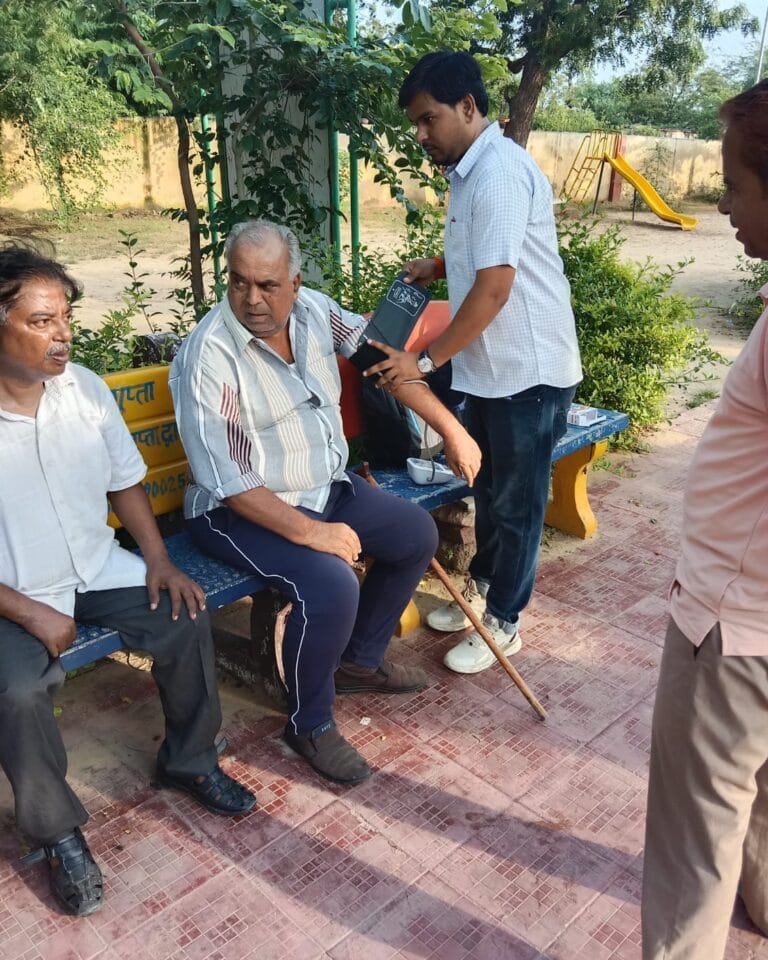 Dr. Harish Kumawat Physiotherapist checking senior citizen's blood pressure in park at Phulera