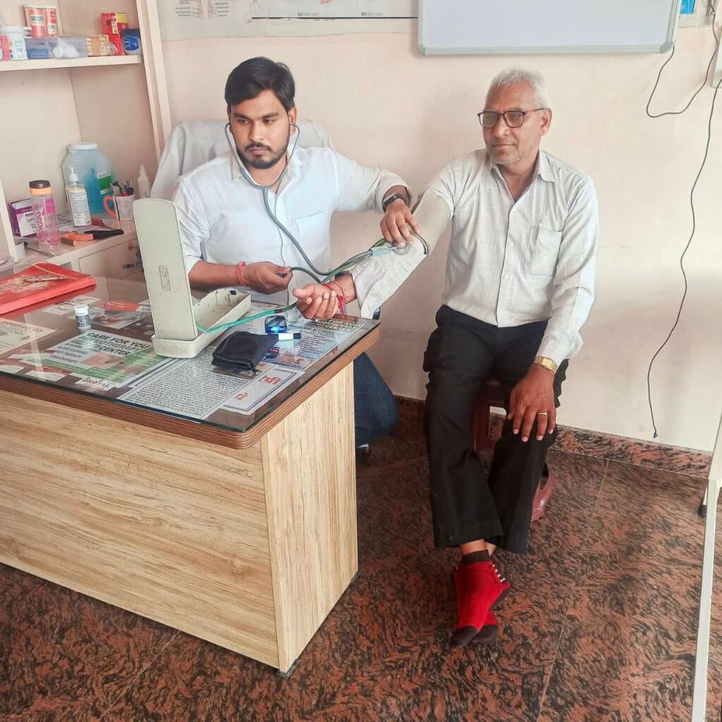 "Dr. Harish Kumar checking blood pressure of a seated patient at the Best Physiotherapy Clinic in Phulera – PhysioCare247"